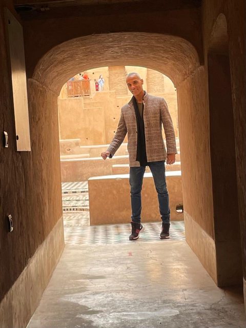 Adil beneath an earthen archway inside a kasbah