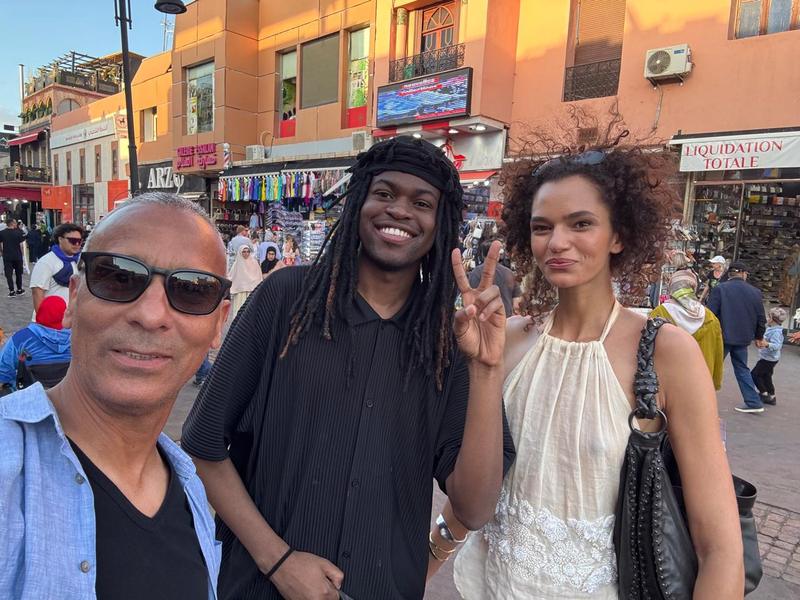 Adil and two guests in a busy medina street