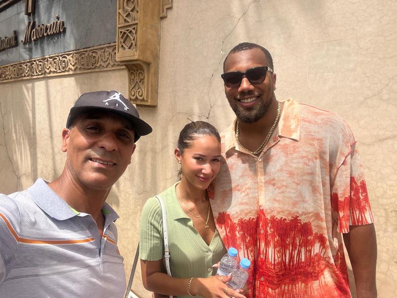 Adil and two guests outside a Moroccan restaurant